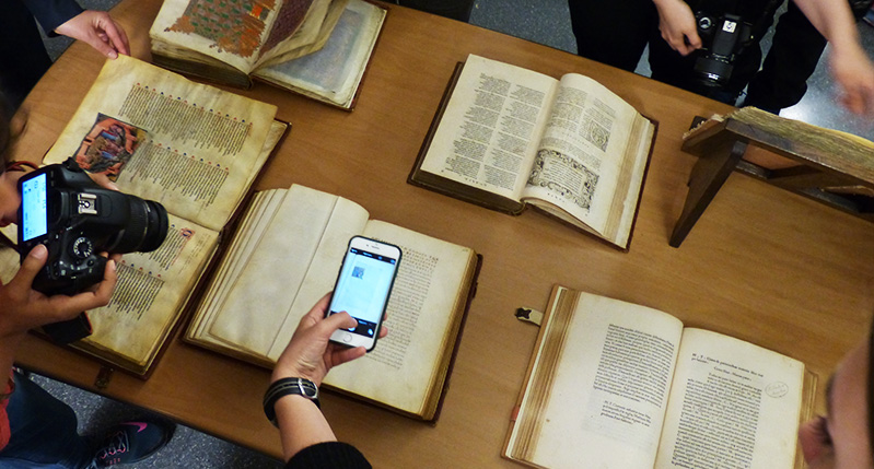 students taking photos of old books