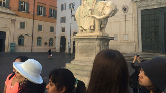 students gathered in front of a elephant statue