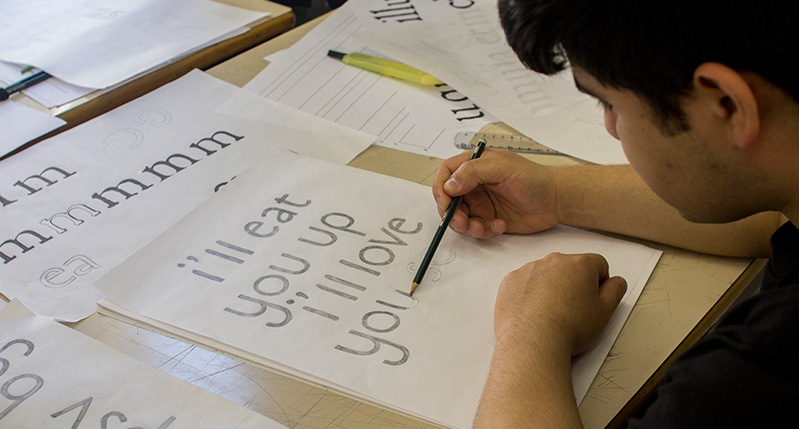 student hand drawing a phrase