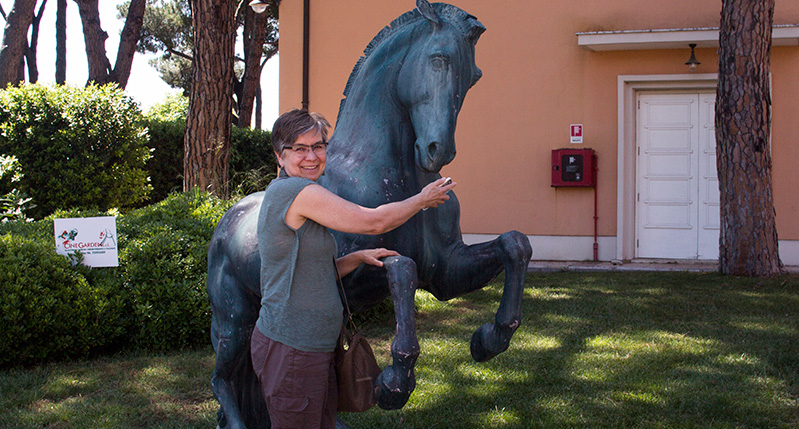 a woman posing with the horse sculpture