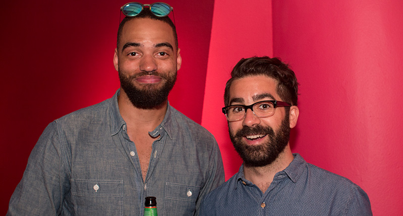 two man in a red background with beer