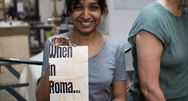 a student holding a when in roma paper