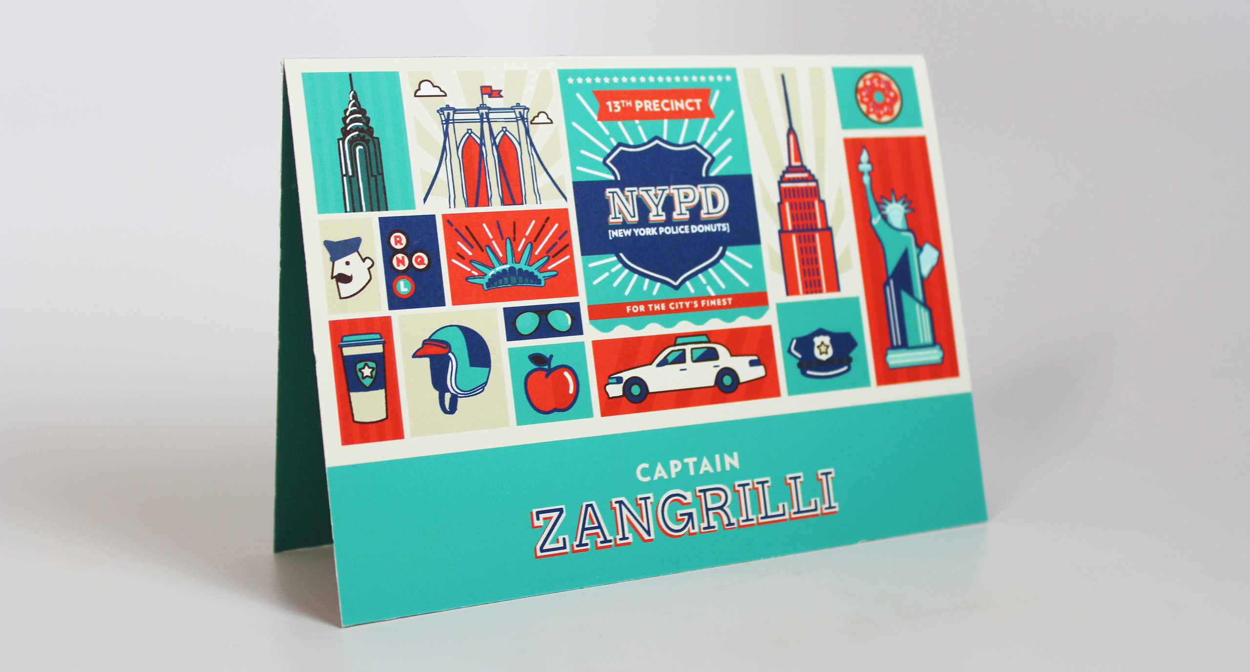 A colorful post card depicting New York landmarks as well as the NYPD logo and items. On it there is a text: Captain Zangrilli.