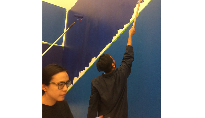 a person painting the wall in blue