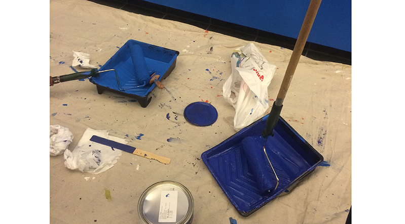 two paint trays with blue paint to start painting the walls