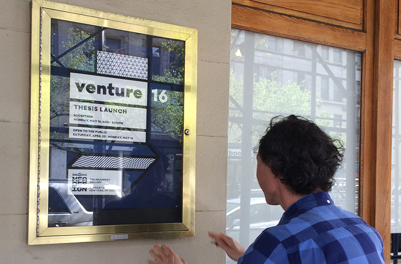 a person looking at the venture 16 event poster in the streets
