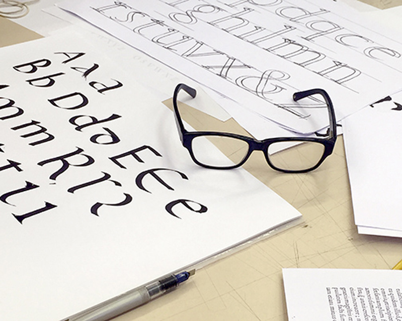 typography papers with glasses on top of table