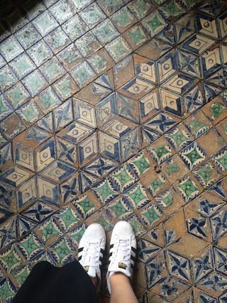someone with sneakers on mosaic tiles