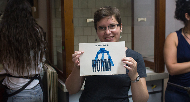 student holding roma print