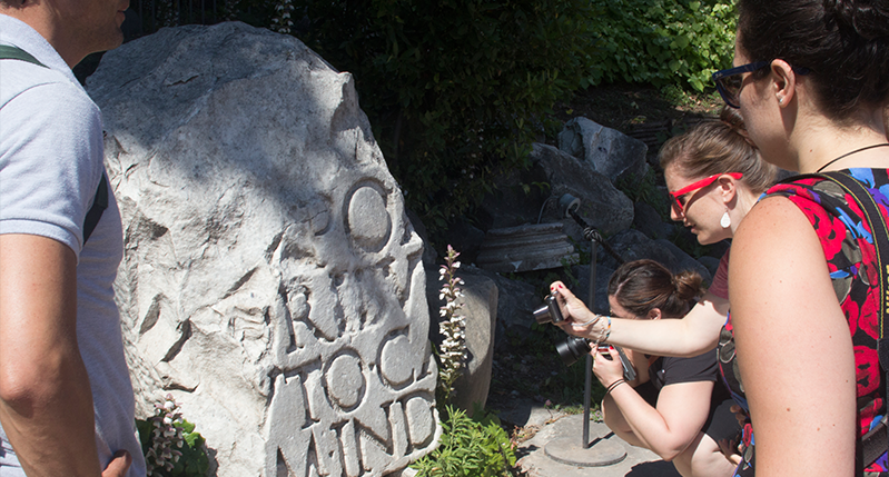 women taking photo of stone with type