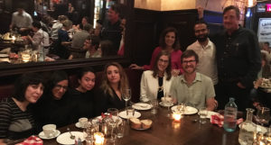 group photo of people sitting at a dinner table
