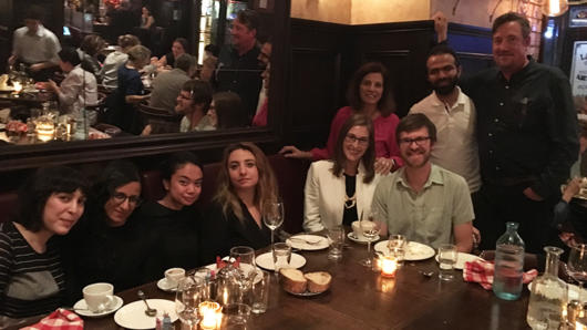 group photo of people sitting at a dinner table