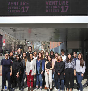 group photo of students and alumni on the sidewalk