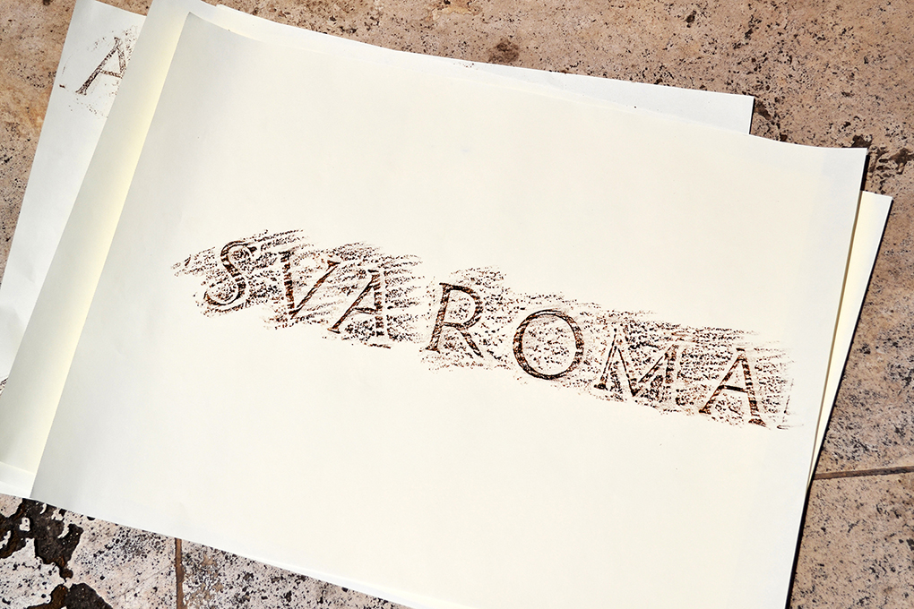 SVA ROMA pen shaved against the page put on the engraved text on the wall