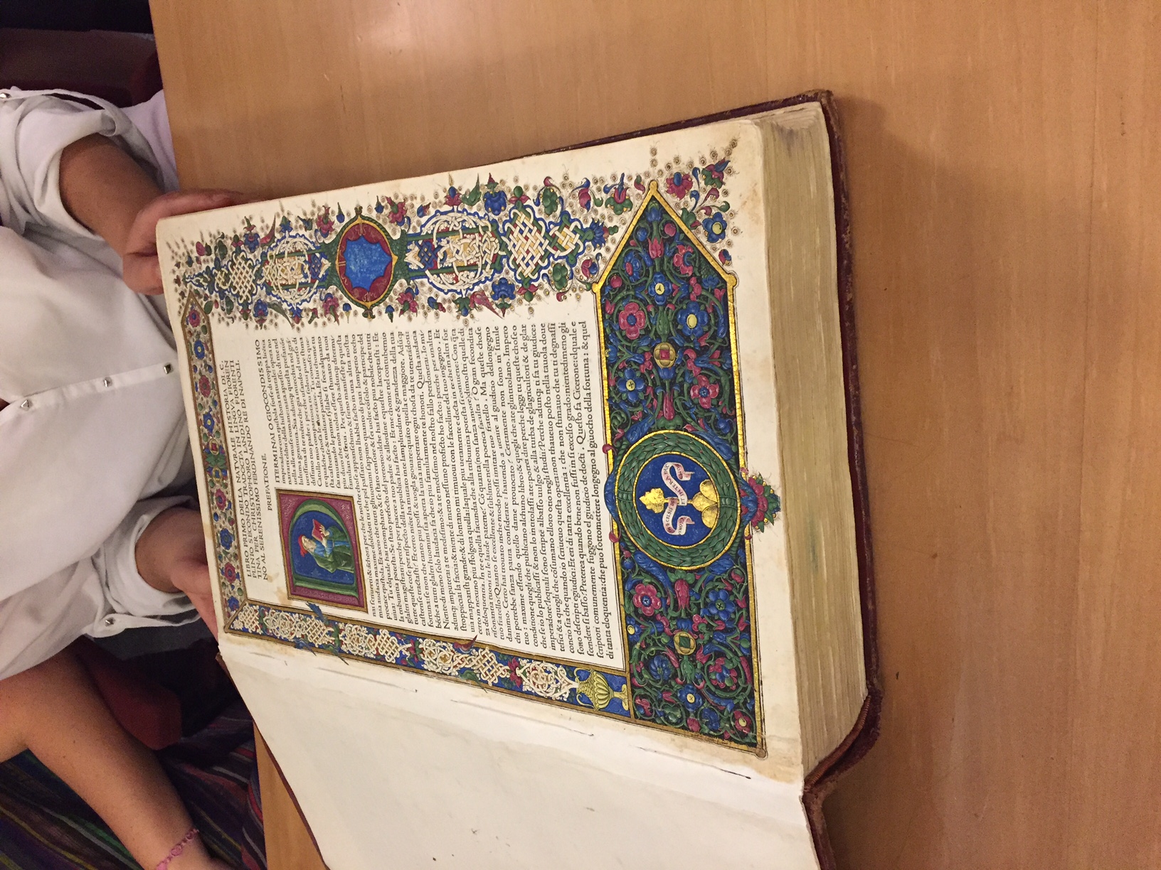 Old book with text surrounded by colorful artwork and drawings.