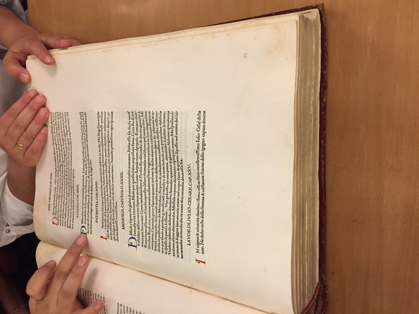 People checking text from an old book written in Latin.