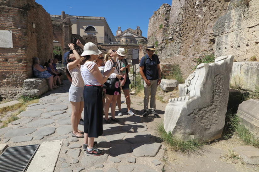 people are looking at a rock sculpture in the ruins site in Rome