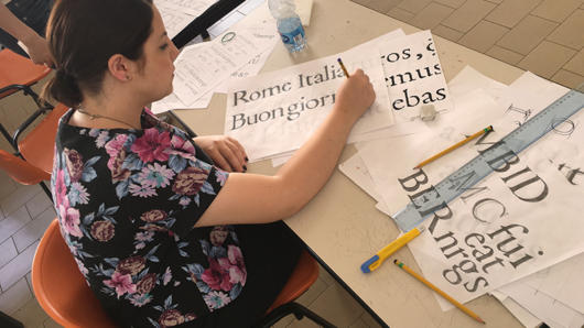 A woman exercising typography at a desk.