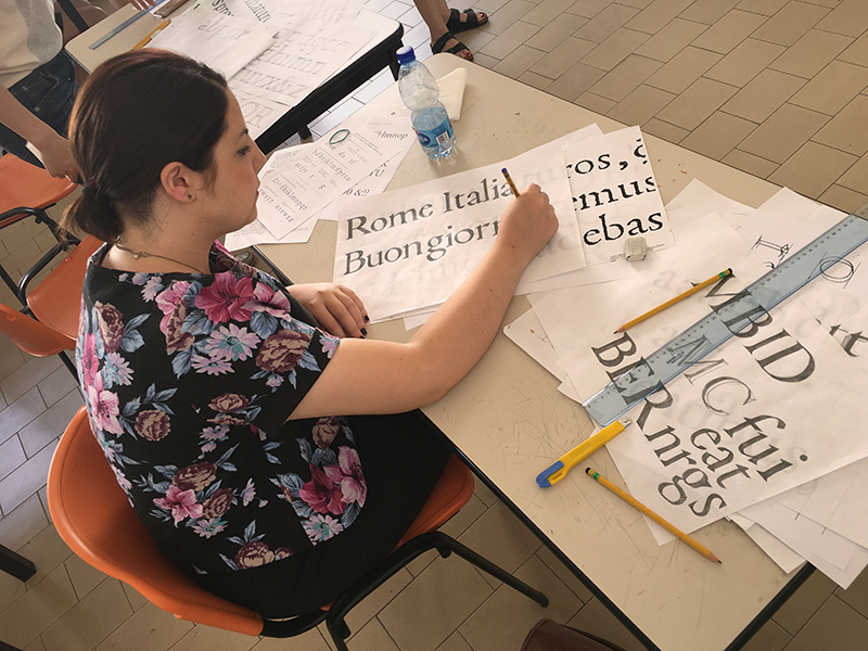 A woman exercising typography at a desk.