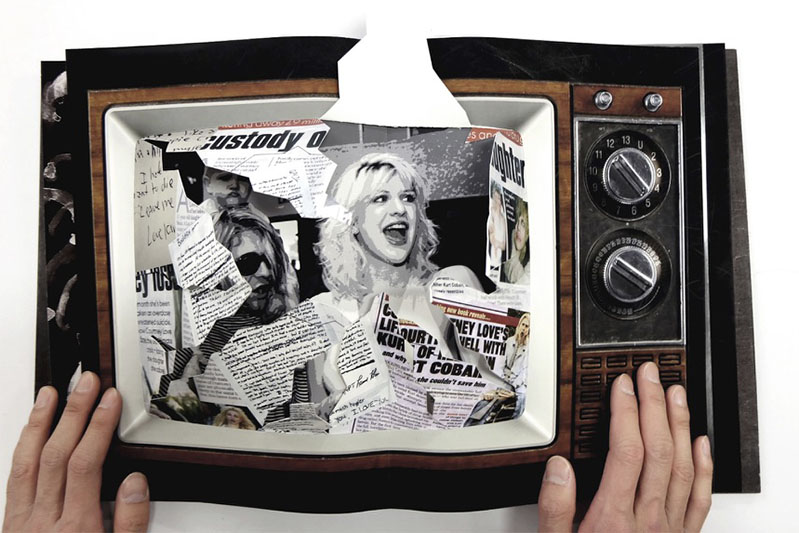 An opened book depicting an old TV set and on its screen a female character surrounded by newspaper pieces.