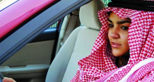 A photo of an Arab woman driving a red car.