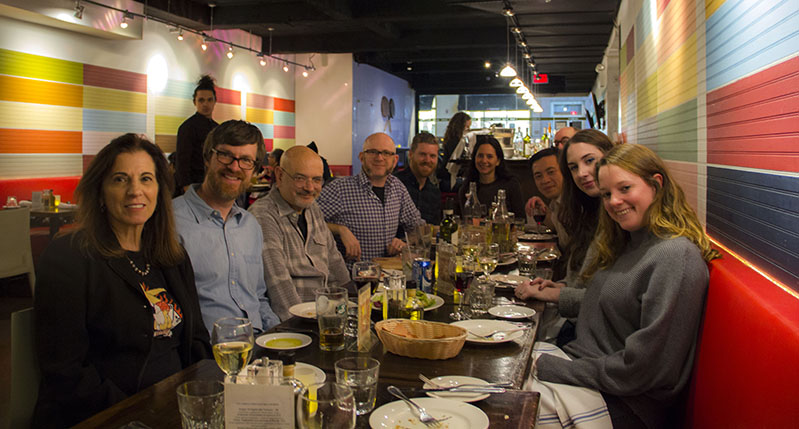 A photo of a group of people siting at a table in a restaurant.