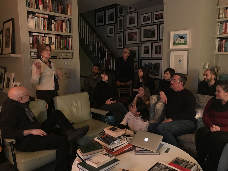 A photo of a group of people siting in the living room and flowing a lecture.