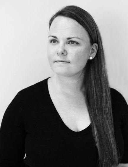 A black and white photo of a girl wearing a blouse.