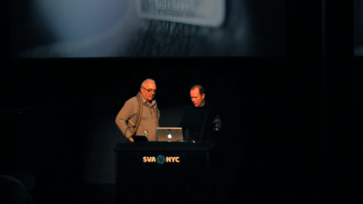 A photo of two people giving a lecture from a laptop on a SVA NYC stand.