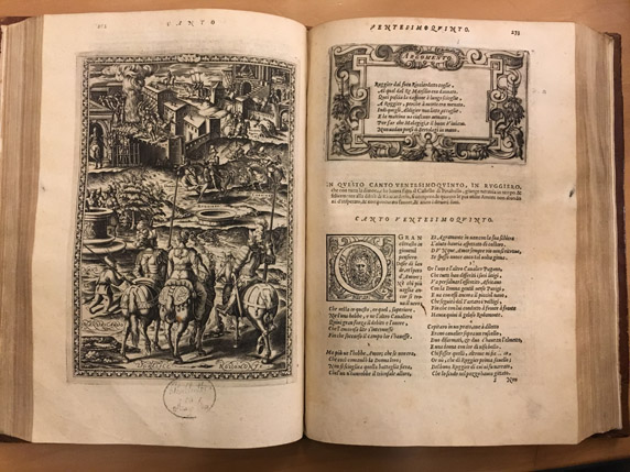 A photo of an opened old book depicting some artistic drawings and text.