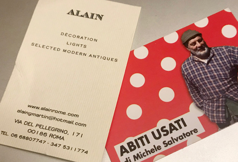 A white and a red paper flier with a man in a checkered shirt. The title on the fliers: Abiti Usati di Michele Salvatore. Alain Decoration Lights Selected Modern Antiques.