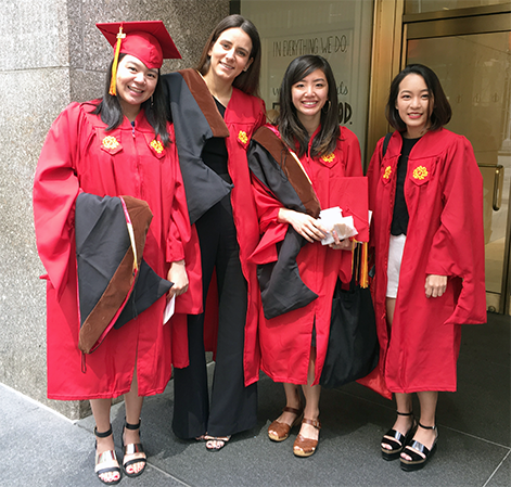 A photo of a group of people wearing black and red robes for the graduation ceremony.