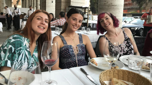 A photo of three girls sitting at a restaurant table.