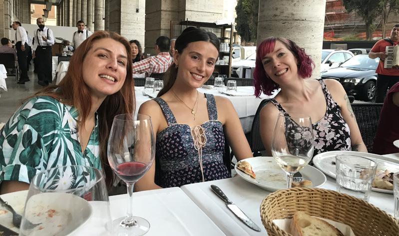 A photo of three girls sitting at a restaurant table.
