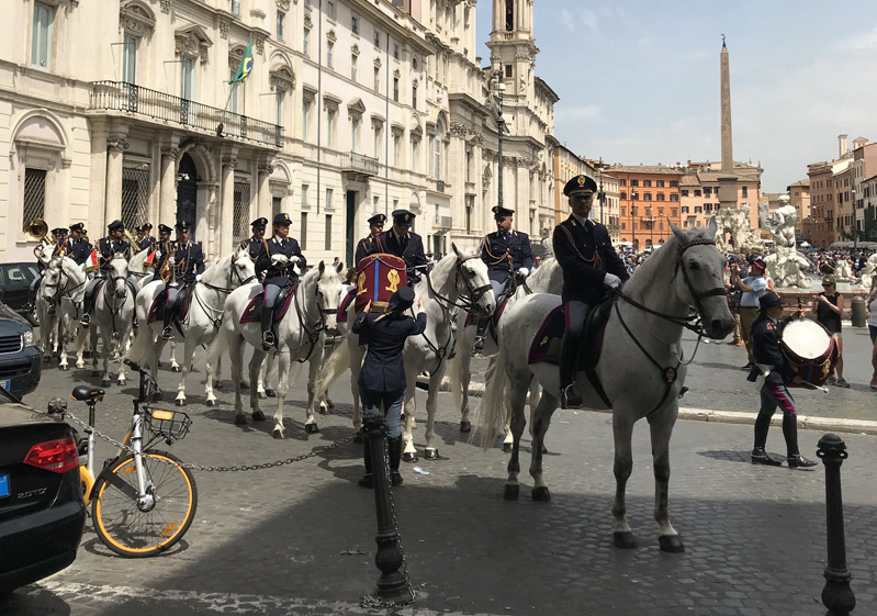 A photo of a group of police officers on white horses in Italy.