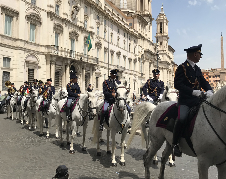 A photo of a group of police officers on white horses in Italy.