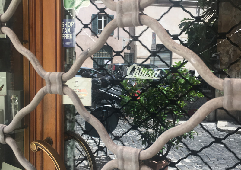 A photo of a window shop locked and over it a fence.