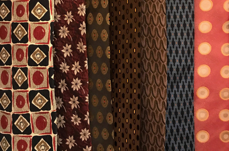 A photo of different colored and pattern pieces of textile material.