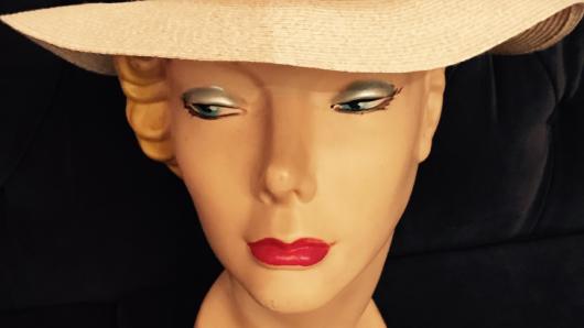 A photo of a white hat on a plastic female head.