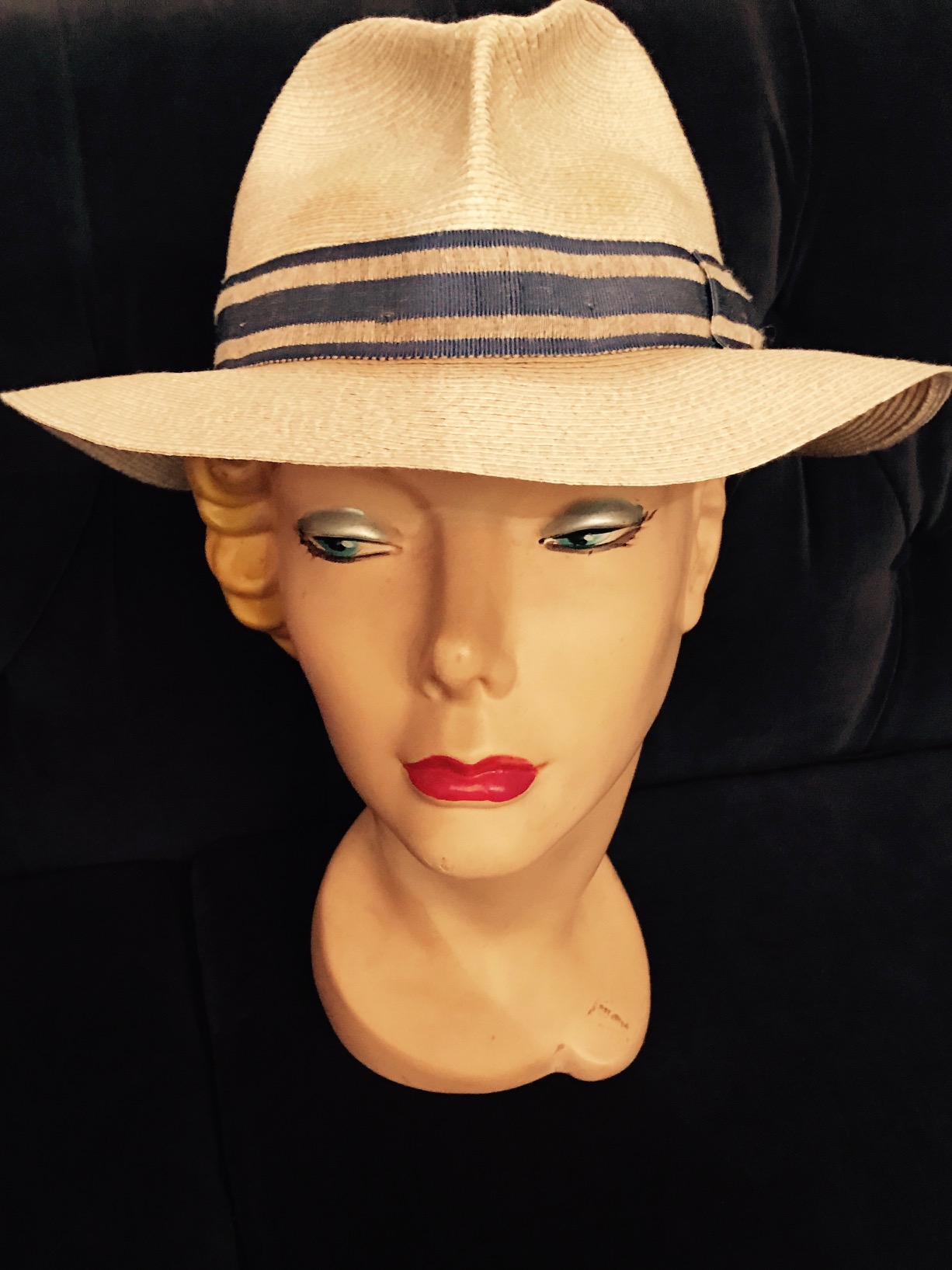 A photo of a white hat on a plastic female head.