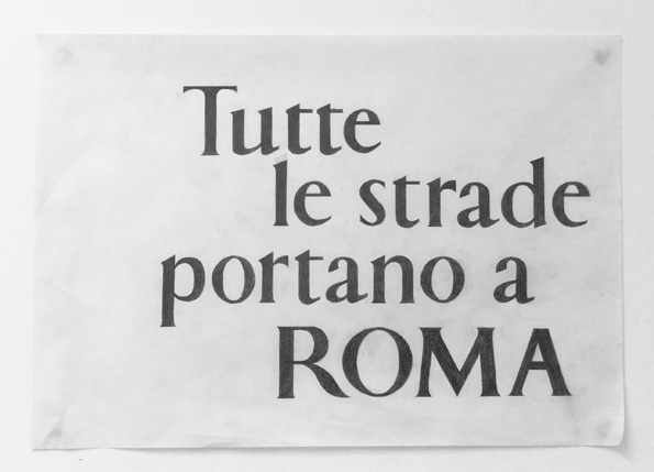A piece of paper with some typographical drawing. The text on it says: Tutte le strade prtano a Roma, meaning that All roads lead to Rome.