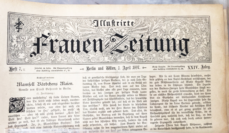 A photo of an old news paper with gothic styled letters and drawings.