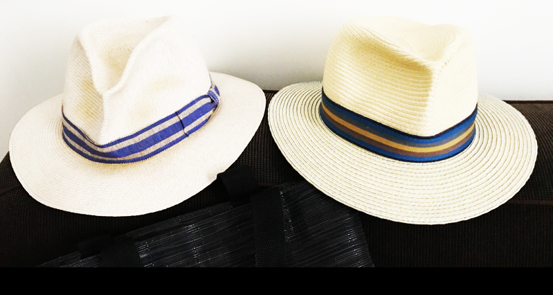 A photo of two white hats with unique ribbons on them.