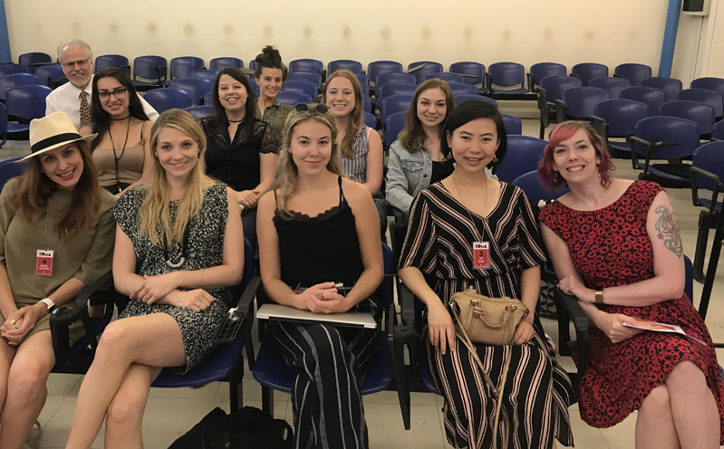 A photo of a group of people sitting in a cinema room.