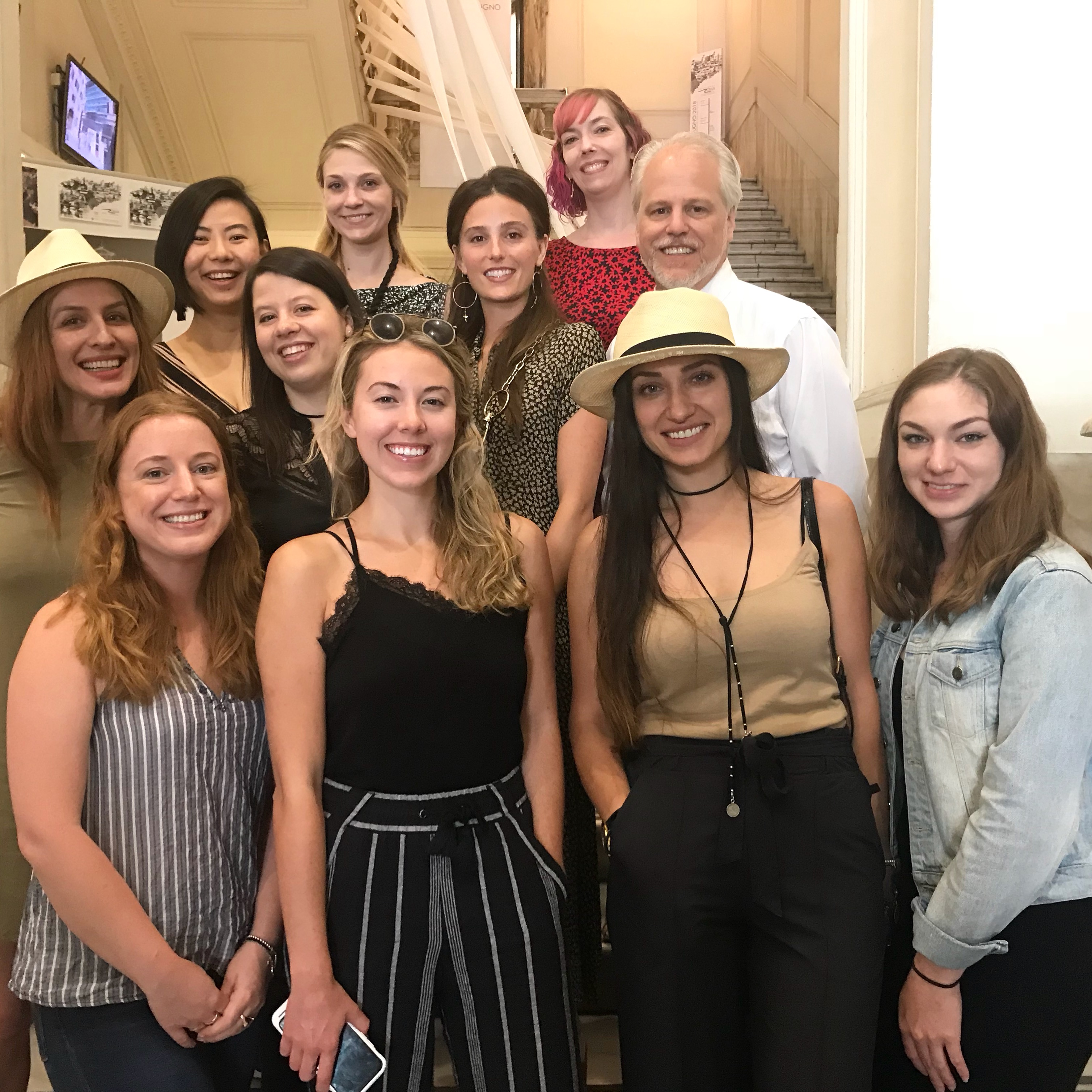 A photo of a group of people standing in a hallway of a building.