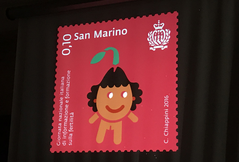 A red stamp with white text and a drawing of a personified brown and green flower.