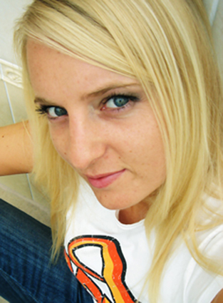 Photograph of a blond girl with white t shirt and jeans.
