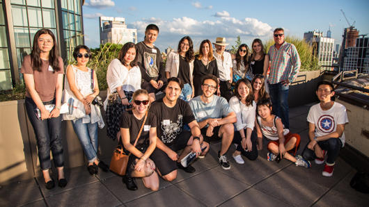 A photo of a group of people in front of a city scape.