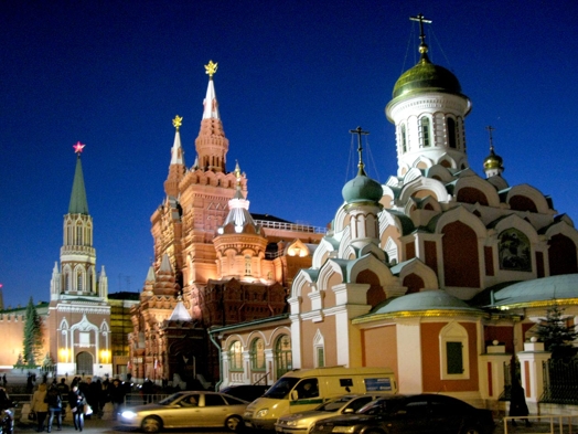 An image depicting a cathedral with green and golden rooftop near the red square wall in Moscow.