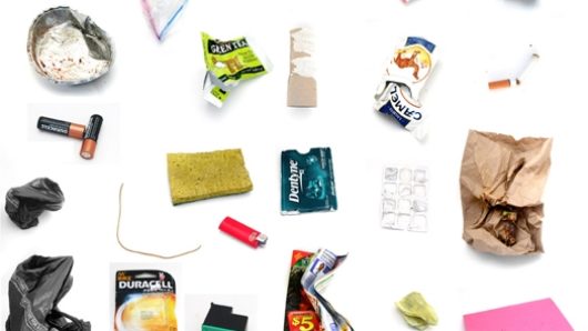 A picture of different objects post-it stickers, batteries, matches, twisted empty cigarette box, empty blister, lighter, apple remain, printing cartridge, sponge, empty toilet paper roller, and other objects.